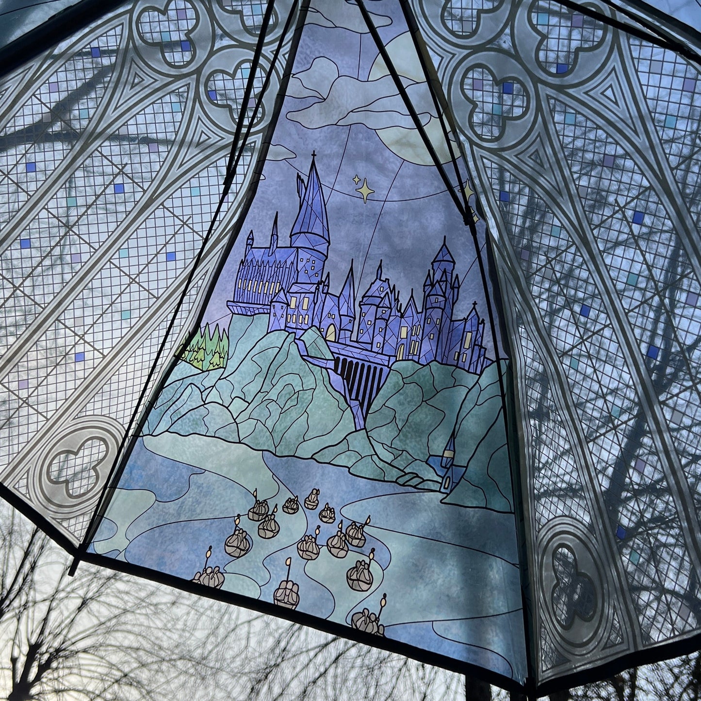 Decorative umbrella with stained glass-style design of a castle and boats.