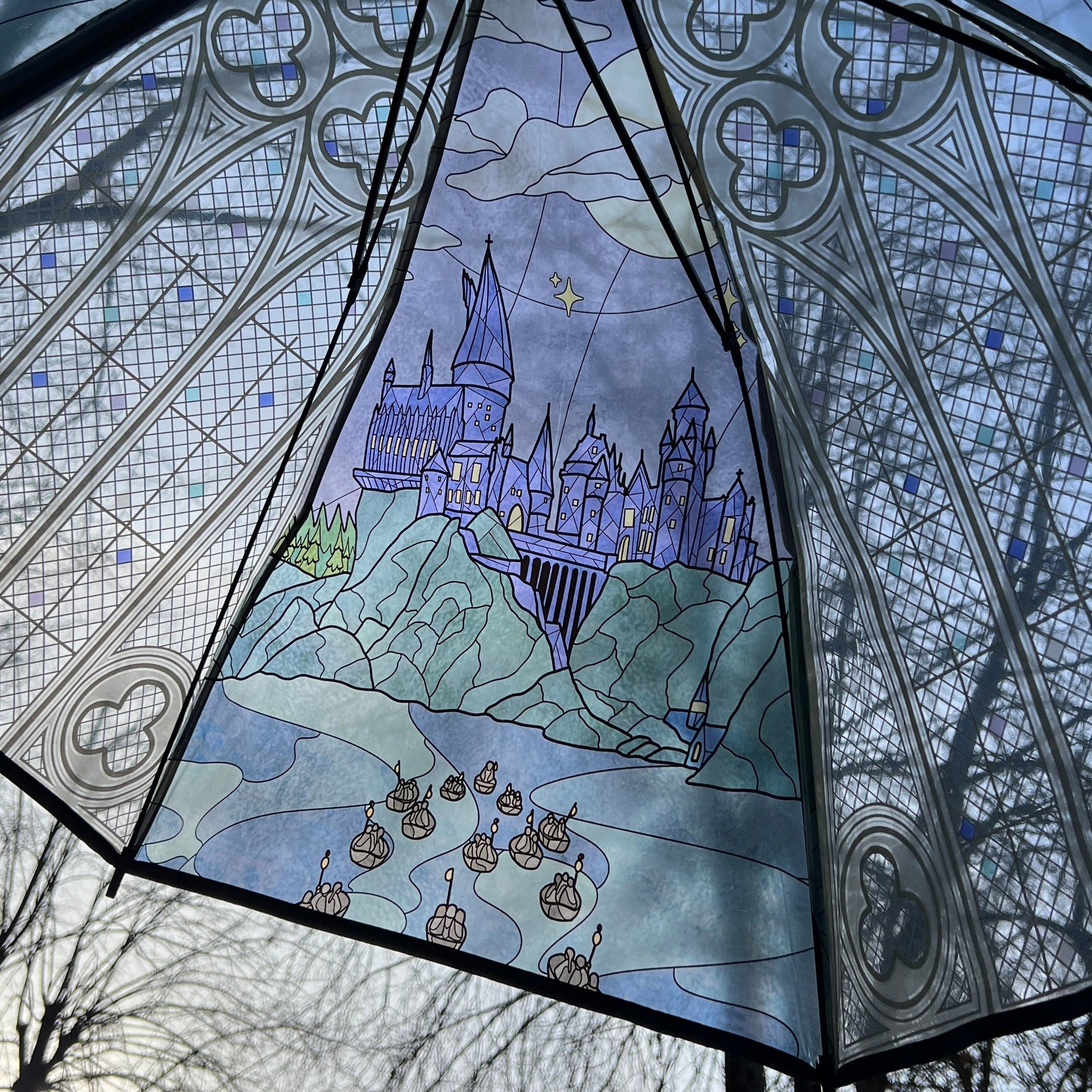 Decorative umbrella with stained glass-style design of a castle and boats.