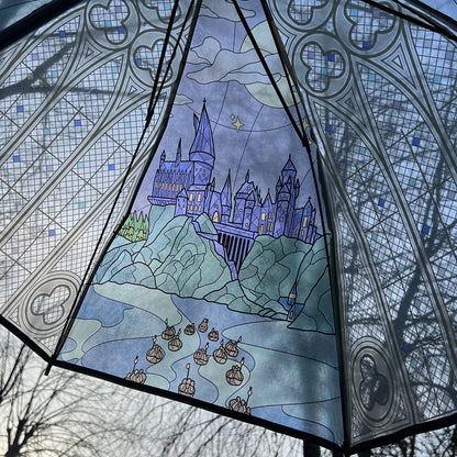 Decorative umbrella with stained glass-style design of a castle and boats.