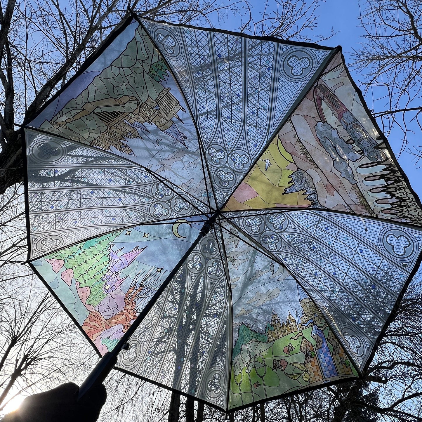 Wizard-inspired stained glass canopy umbrella featuring illustrated panels of a magical castle, whimsical crooked house, enchanted willow tree, grand candlelit dining hall, and vintage steam train.