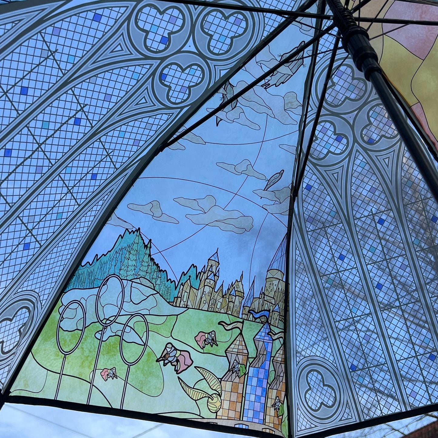 Decorative umbrella with stained glass design featuring a castle and landscape.