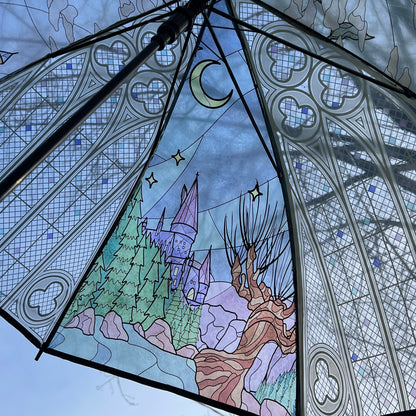 Umbrella with stained glass design featuring a castle and trees