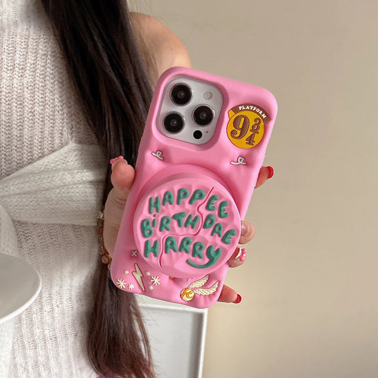 Pink phone case with 'Happy Birthday Harry' text held by a person