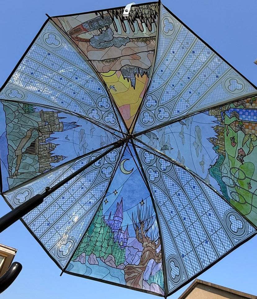 Decorative umbrella with colorful illustrations against a clear blue sky