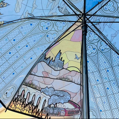 Umbrella with artistic design of a castle and landscape on a blue patterned background